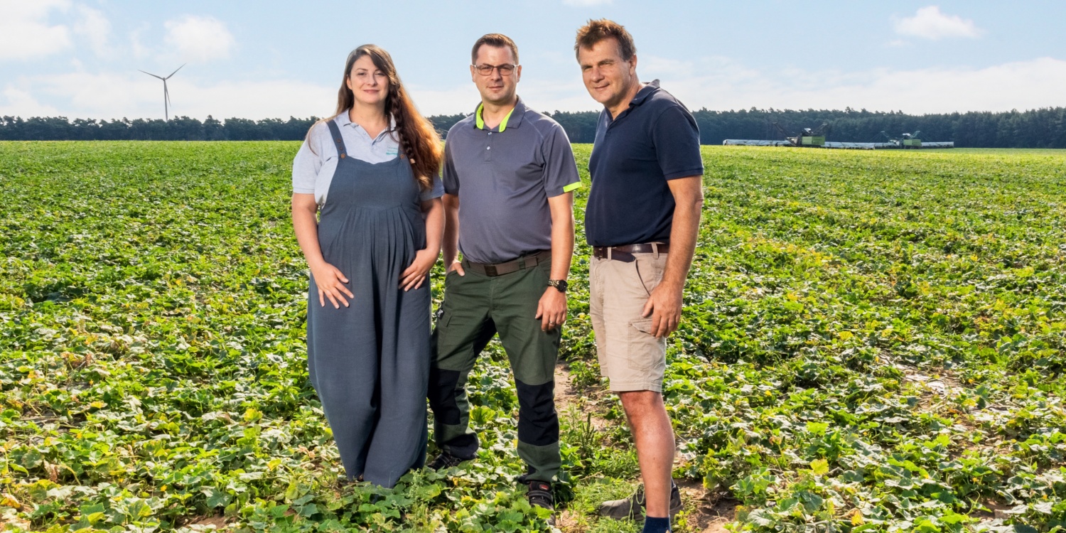 Familie Frehn gemeinsam vor den Feldern ihres Biohofs.