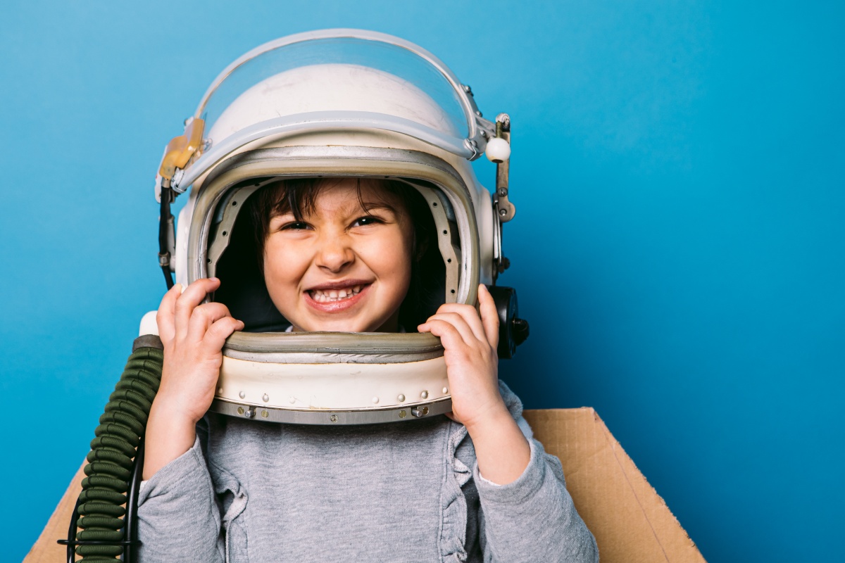 Ein Kind trägt einen Astronautenhelm als Kostüm zum Fasching.